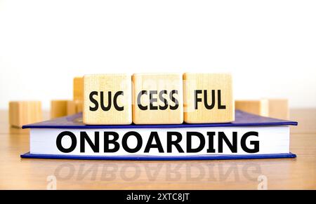 Simbolo di inserimento riuscito. Concetto di successo onboarding su cubi di legno. Bellissimo tavolo in legno su sfondo bianco. Bel libro. Business su Foto Stock