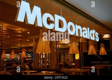 Vista interna del ristorante McDonald's con arredamento contemporaneo in legno. Moderno ristorante fast food interno con chioschi self service. Copenhagen, Denmar Foto Stock