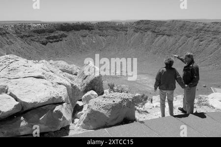 Coppia caucasica di età compresa tra i 50 e i 60 anni ammirando la vasta distesa del cratere Meteor situata sulla Route 66, vicino a Winslow, Arizona. STATI UNITI Foto Stock