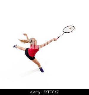 veduta aerea di una giocatrice di badminton che salta in movimento per colpire il rubinetto sullo sfondo bianco dello studio. Foto Stock