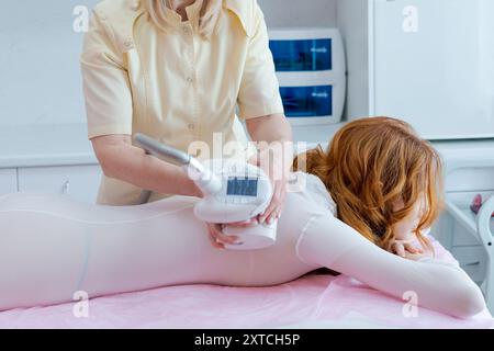 Una donna sta ricevendo un trattamento per il contorno del corpo Foto Stock