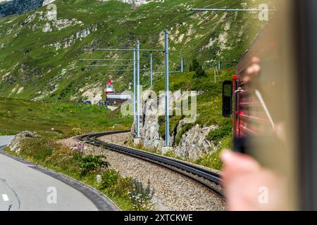 Vista dal Pullman Express Alpine Classic del faro di Rheinquelle sul passo Oberalp di Graubünden, a 2046 metri sul livello del mare. Il faro è una replica del faro di Hoek van Holland, che ha segnato la foce del Reno nel Mare del Nord per 70 anni fino al 1990. Presso il centro informazioni alle sorgenti del Reno si trova una piccola copia del faro di Hoek van Holland, il cui originale si trova alla foce del Reno vicino a Rotterdam. Via Pardé, Tujetsch, Grigioni, Svizzera Foto Stock