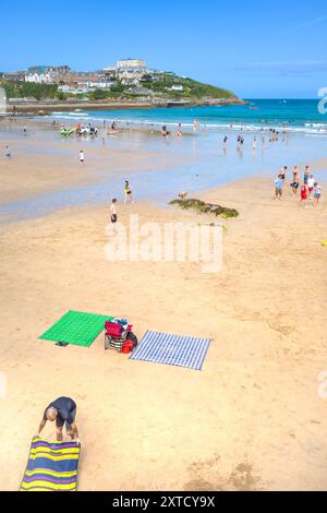 I turisti si rilassano sulla spiaggia di Towan a Newquay, in Cornovaglia, nel Regno Unito. Foto Stock