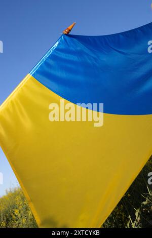 Primo piano di una grande bandiera Ucraina di raso giallo-blu contro il cielo. Simbolo nazionale di libertà. Giornata dell'indipendenza. Sostieni l'Ucraina Foto Stock