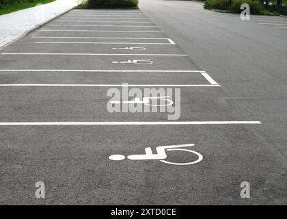 posti auto vuoti per disabili e disabili con segnaletica stradale speciale Foto Stock