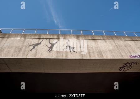 Banksy tre scimmie oscillanti sul ponte ferroviario Brick Lane a Shoreditch Londra, 13 agosto 2024, parte della sua collezione di zoo Foto Stock