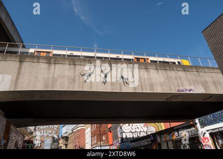 Banksy tre scimmie oscillanti sul ponte ferroviario Brick Lane a Shoreditch Londra, 13 agosto 2024, parte della sua collezione di zoo Foto Stock