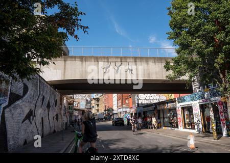 Banksy tre scimmie oscillanti sul ponte ferroviario Brick Lane a Shoreditch Londra, 13 agosto 2024, parte della sua collezione di zoo Foto Stock