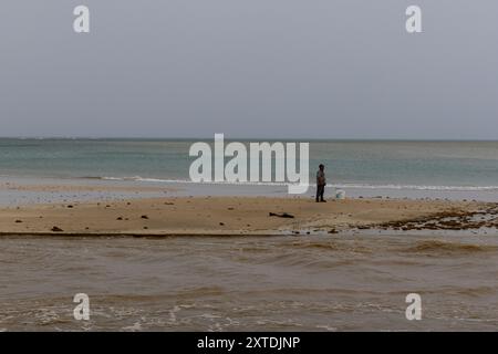 I portoricani pescano in mezzo alle inondazioni causate dalla tempesta tropicale Ernesto a Río grande Beach a Río grande, Porto Rico il 14 agosto 2024. Il Presidente Biden ha approvato una dichiarazione di emergenza per Porto Rico martedì sera tardi. Crediti: SIPA USA/Alamy Live News Foto Stock