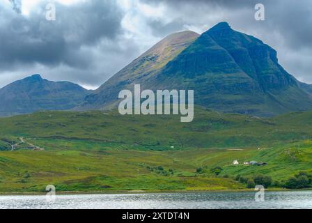 Quinag domina maestosamente il Loch Glencoul, mostrando l'aspra bellezza delle Highlands scozzesi sotto un cielo pieno di nuvole spettacolari. Foto Stock