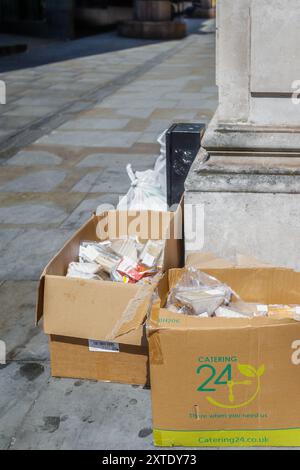 Panini scartati in scatole di cartone lasciati al sole in un angolo di strada a Londra. Foto Stock