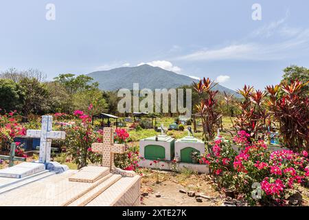 Ometepe, Nicaragua - 21 marzo 2024 cimitero colorato con vulcano sullo sfondo sull'isola di Ometepe nel sud-ovest del Nicaragua, America centrale Foto Stock