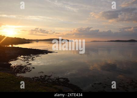 nuvole riflesse sulle acque calme al tramonto Foto Stock