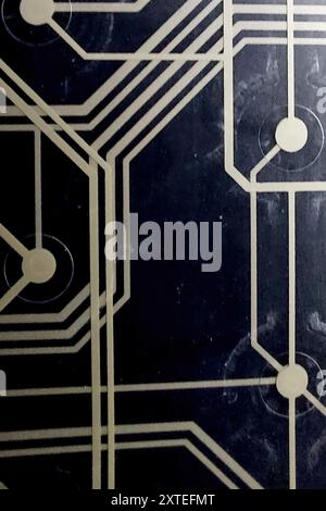 Una vista dettagliata di una scheda a circuito stampato con guide di cablaggio stampate su sfondo nero, che illustra il design elettronico complesso. Foto Stock