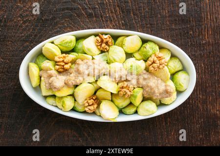 Piatto di souffle con cavolini di Bruxelles cotti con noci e salsa miso di noci al limone. Foto Stock