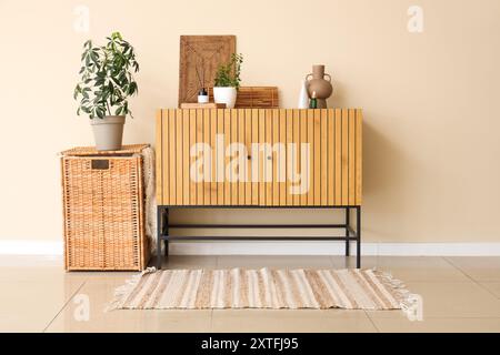 Diffusore di aromi, decorazioni in vimini e piante d'appartamento sul cassettiere del soggiorno Foto Stock