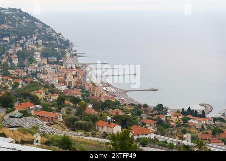 Una pittoresca cittadina italiana adagiata su una collina che si affaccia su un mare calmo e blu, con una spiaggia che si estende lungo la costa. Foto Stock