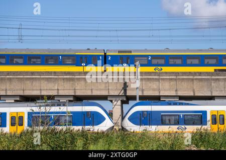 Treni della Dutch Railways, NS, Nederlandse Spoorwegen N.V., su binario a due piani, sotto il treno locale Sprinter Light Train, sopra Intercity Direc Foto Stock