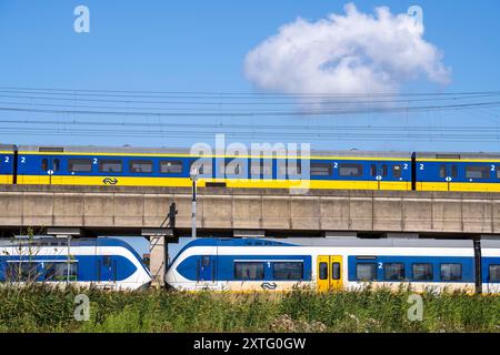 Treni della Dutch Railways, NS, Nederlandse Spoorwegen N.V., su binario a due piani, sotto il treno locale Sprinter Light Train, sopra Intercity Direc Foto Stock