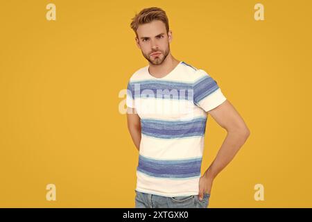Uno stile estivo da uomo con camicia a righe. modello uomo in studio estivo. uomo che indossa un outfit estivo. Un uomo mostra il suo stile estivo con la maglietta i Foto Stock