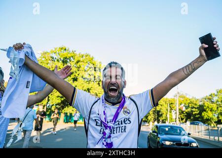 Un tifoso del Real Madrid si eccita prima della partita. I tifosi dei vincitori della Champions League spagnola, del Real Madrid e della Coppa UEFA italiana, l'Atalanta, si sono riuniti in piazza Kahla a Varsavia, accanto al fiume Vistola, per il festival dei tifosi della Supercoppa UEFA. In previsione della partita di quella sera, i visitatori fanno la fila per scattare foto con il trofeo e partecipare a diverse partite e attività legate al calcio, prima di recarsi allo stadio per la partita. La Supercoppa UEFA si svolge al PGE Narodowy di Varsavia il 14 agosto 2024 ed è contesa dai vincitori della Champions League e della Coppa UEFA wi Foto Stock