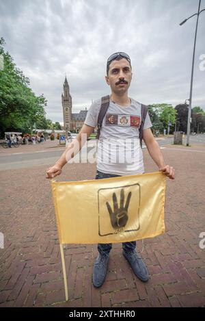 L'Aia, Paesi Bassi. 14 agosto 2024. Un manifestante detiene una bandiera durante la manifestazione "11 anni di vergogna”. Il 14 agosto 2013, la polizia egiziana e, in misura minore, l'esercito hanno usato la forza letale per "disperdere" due campi di manifestanti pacifici a Cario: Erano oppositori del colpo di Stato militare in piazza Rabaa al-Adwija e in piazza al-Nahda. Più di 900 persone sono state uccise quel giorno, e da allora più di 100.000 persone sono state imprigionate e centinaia di altre sono scomparse. (Foto di Charles M Vella/SOPA Images/Sipa USA) credito: SIPA USA/Alamy Live News Foto Stock