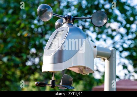 La stazione meteorologica individuale con una pala nera è montata su un palo in un giardino. Meteorologia personale e previsioni meteorologiche Foto Stock