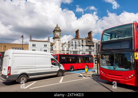 Autobus rossi sulla strada trafficata vicino alla torre dell'orologio vittoriano nel quartiere di Clapham. Londra, Inghilterra Foto Stock