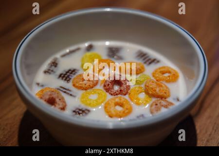 Cereali con latte in un recipiente su un tavolo di legno Foto Stock