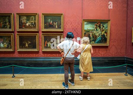 Interno della Galleria Nazionale. All'interno del museo d'arte London National Gallery in Trafalgar Square, con i visitatori del museo che ammirano dipinti e opere d'arte. Foto Stock