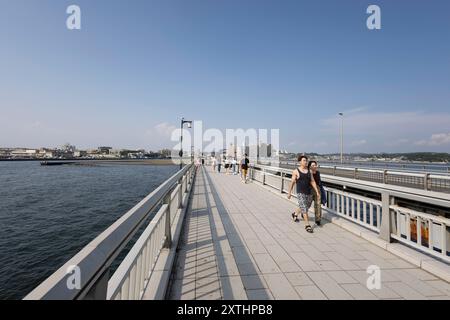 Enoshima, Giappone. 8 agosto 2024. Una coppia cammina sul ponte Enoshima Benten in una giornata estiva di sole. Credito: SOPA Images Limited/Alamy Live News Foto Stock