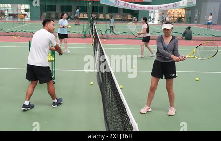 (240815) -- PECHINO, 15 agosto 2024 (Xinhua) -- gli studenti adulti partecipano a una lezione di tennis in un club di tennis a Pechino, Cina, 14 agosto 2024 la Cina ha recentemente sperimentato un aumento dell'entusiasmo per il tennis, come dimostra un notevole aumento della domanda di corsi di formazione e prenotazioni di campi in varie città. Questo picco può essere attribuito alla storica vittoria del tennista cinese Zheng Qinwen, che ha conquistato la prima medaglia d'oro del tennis olimpico cinese alle Olimpiadi di Parigi. Vale la pena ricordare che non solo più adulti hanno praticato il tennis come attività ricreativa, ma anche un increasi Foto Stock