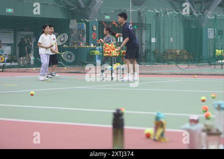 (240815) -- PECHINO, 15 agosto 2024 (Xinhua) -- bambini gli studenti partecipano a un campo estivo di tennis in un club di tennis a Pechino, Cina, 14 agosto 2024 la Cina ha recentemente sperimentato un aumento dell'entusiasmo per il tennis, come evidenziato da un notevole aumento della domanda di corsi di formazione e prenotazioni di campi in varie città. Questo picco può essere attribuito alla storica vittoria del tennista cinese Zheng Qinwen, che ha conquistato la prima medaglia d'oro del tennis olimpico cinese alle Olimpiadi di Parigi. Vale la pena ricordare che non solo più adulti hanno praticato il tennis come attività ricreativa, ma anche un Foto Stock