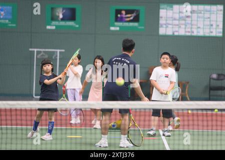 (240815) -- PECHINO, 15 agosto 2024 (Xinhua) -- bambini gli studenti partecipano a un campo estivo di tennis in un club di tennis a Pechino, Cina, 14 agosto 2024 la Cina ha recentemente sperimentato un aumento dell'entusiasmo per il tennis, come evidenziato da un notevole aumento della domanda di corsi di formazione e prenotazioni di campi in varie città. Questo picco può essere attribuito alla storica vittoria del tennista cinese Zheng Qinwen, che ha conquistato la prima medaglia d'oro del tennis olimpico cinese alle Olimpiadi di Parigi. Vale la pena ricordare che non solo più adulti hanno praticato il tennis come attività ricreativa, ma anche un Foto Stock