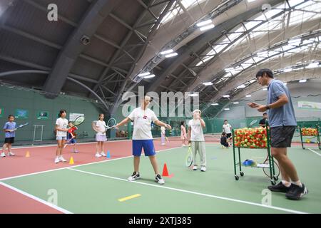 (240815) -- PECHINO, 15 agosto 2024 (Xinhua) -- bambini gli studenti partecipano a un campo estivo di tennis in un club di tennis a Pechino, Cina, 14 agosto 2024 la Cina ha recentemente sperimentato un aumento dell'entusiasmo per il tennis, come evidenziato da un notevole aumento della domanda di corsi di formazione e prenotazioni di campi in varie città. Questo picco può essere attribuito alla storica vittoria del tennista cinese Zheng Qinwen, che ha conquistato la prima medaglia d'oro del tennis olimpico cinese alle Olimpiadi di Parigi. Vale la pena ricordare che non solo più adulti hanno praticato il tennis come attività ricreativa, ma anche un Foto Stock