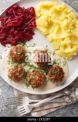 Polpette con purè di patate e insalata di barbabietole da vicino in un piatto sul tavolo. Vista dall'alto verticale Foto Stock