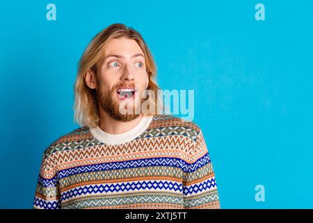 Foto di un bel giovane uomo che sembra uno spazio vuoto indossa un pullover isolato su uno sfondo color verde acqua Foto Stock