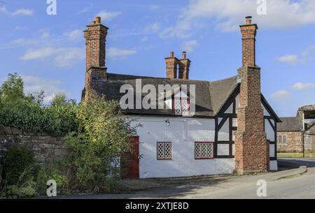 Beeston, Cheshire West e Chester, Regno Unito - 14 agosto 2024 - edificio in legno rosso, bianco e nero con grandi camini Foto Stock