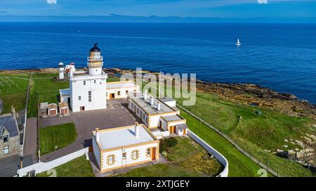 Fari di Kinnaird Head a Fraserburgh cielo estivo blu sopra lo yacht degli edifici con vela bianca sul mare Foto Stock