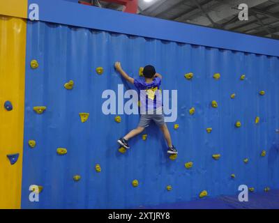 Farnborough, Hampshire, Regno Unito - giovedì 15 agosto 2024 bambino pratica le sue abilità di arrampicata nello stand eBay durante il SALONE AUTOMOBILISTICO BRITANNICO del 2024 tenutosi presso il famoso aeroporto e centro fieristico di Farnborough credito: Motofoto/Alamy Live News Foto Stock