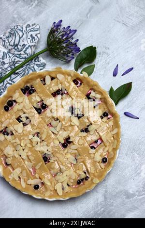 Torta di frutti di bosco fatta in casa su sfondo di cemento. Vista dall'alto. Torta di frutti di bosco fatta in casa cruda su sfondo di cemento. Vista dall'alto. Foto Stock