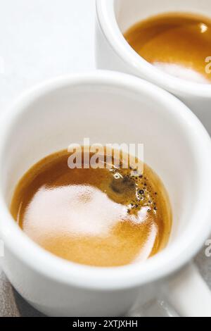 Primo piano immagine verticale di due tazze di caffè con crema meravigliosa nella vista dall'alto del tavolo Foto Stock