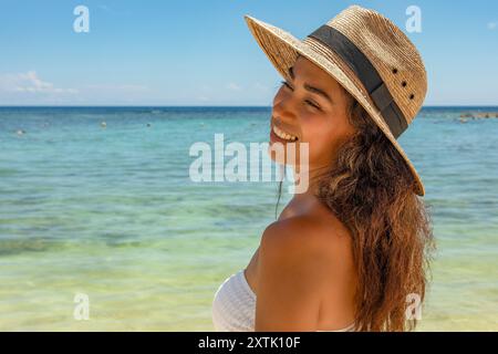 Senti il calore del sole caraibico sulla tua pelle mentre il nostro modello si crogiola nel paradiso più assoluto. La nostra bellezza baciata dal sole sta vivendo il sogno Foto Stock