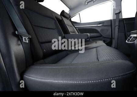 Comodo divano posteriore per auto di colore grigio con bracciolo aperto e finestre isolate con vista laterale Foto Stock