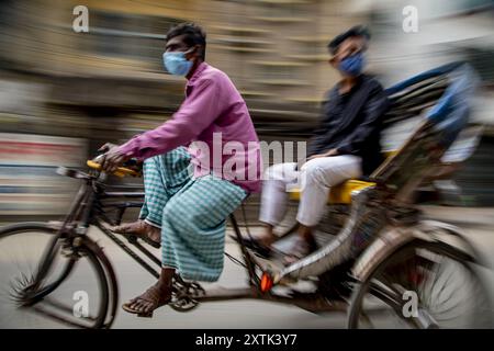 Pulitori di risciò per le strade di Puran Dhaka - Old Dhaka in Bangladesh. I risciò sono tricicli alimentati a pedale, ma usati per essere tirati a mano, da qui 'estrattore di risciò'. Oggi molti dei risciò sono persino convertiti per essere alimentati da un motore elettrico. Foto Stock