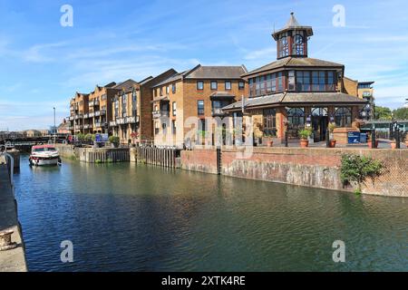 Una barca entra nel Limehouse Basin di Londra attraverso la chiusa dal fiume Tamigi. Il molo vittoriano è ora convertito in un porticciolo per yacht. Foto Stock