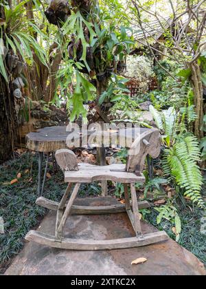 Il vecchio cavallo a dondolo in legno nel giardino, bambini e giovani gioiosi per rilassarsi nella caffetteria, vista frontale con spazio per le copie. Foto Stock