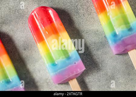 Dolci papaveri arcobaleno estivi con diversi sapori di frutta, disposti su sfondo grigio Foto Stock