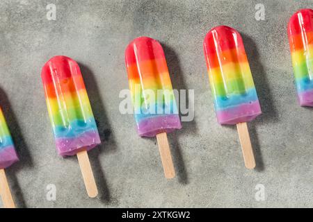 Dolci papaveri arcobaleno estivi con diversi sapori di frutta, disposti su sfondo grigio Foto Stock