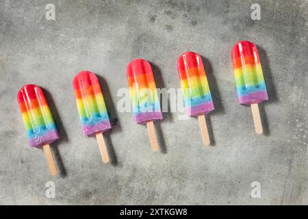Dolci papaveri arcobaleno estivi con diversi sapori di frutta, disposti su sfondo grigio Foto Stock